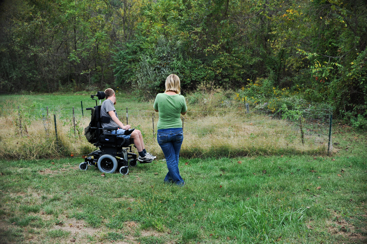 Noah Trembly and his aid Terra Hart look over Noah's garden in Athens, Ohio, in late October 2010. "It's autumn, the tomatoes are green", Noah types on his communication board. Terra worked as Noah's day aid for six months.