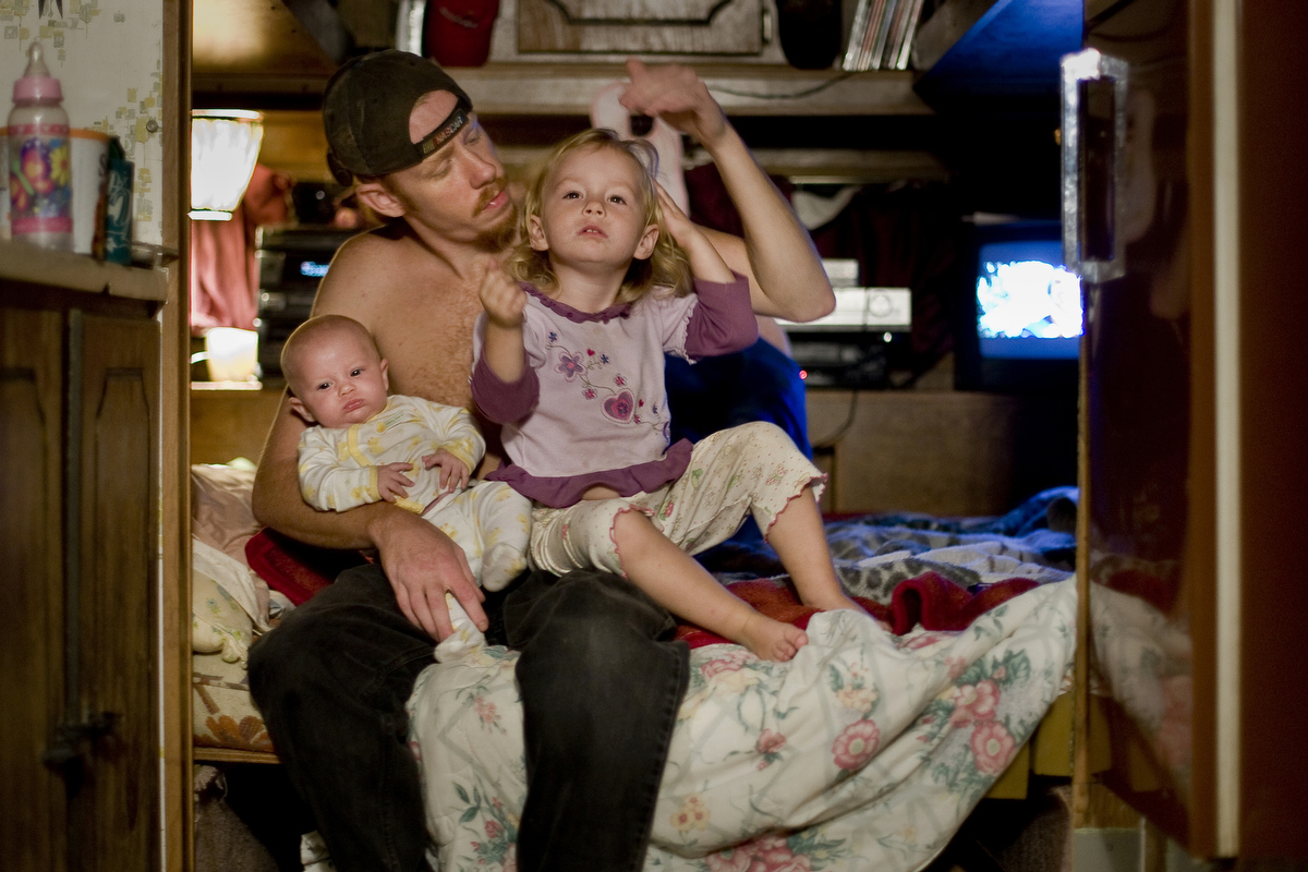 Travis holds his daughters, Journey and Patience, on the first night of his release from jail into home confinement. When Travis began his home confinement sentence Journey was three months old and Patience three years old.