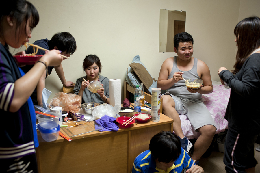 A group of friends make noodles in a rice cooker in their room. Cooking is forbidden in Scott, so a plastic bag covers the smoke detector to avoid getting caught. From left: Ma Wen Qi, Zhou Yi Ming, Song Kai Li, Monroe Pan, Bill Zhang, and Zhu Zi Yang.